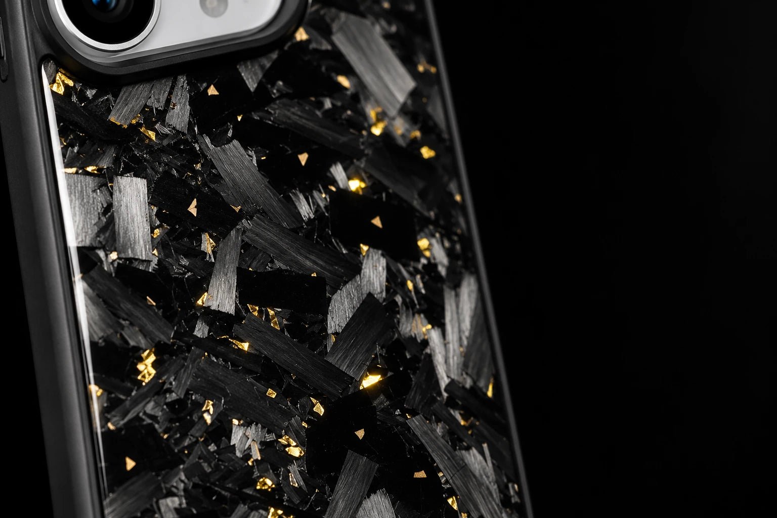Gold accents among large forged carbon flakes, photographed in close-up